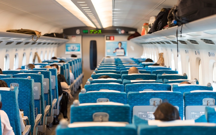 Passengers seated inside a Shinkansen train traveling from Tokyo, Japan.