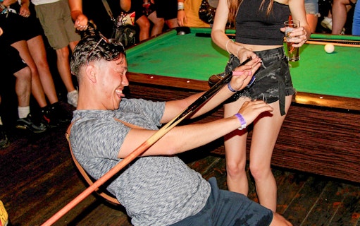 Person enjoying limbo game during Amsterdam Red Light District pub crawl.
