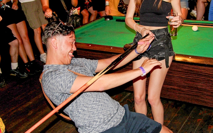 Person enjoying limbo game during Amsterdam Red Light District pub crawl.