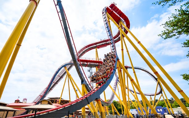 Roller coaster at Six Flags Fiesta Texas, Dr. Diabolical's Cliffhanger, with riders on steep drop.