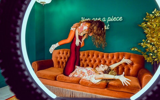 Visitors posing creatively on a sofa at Thessaloniki Selfie Museum.