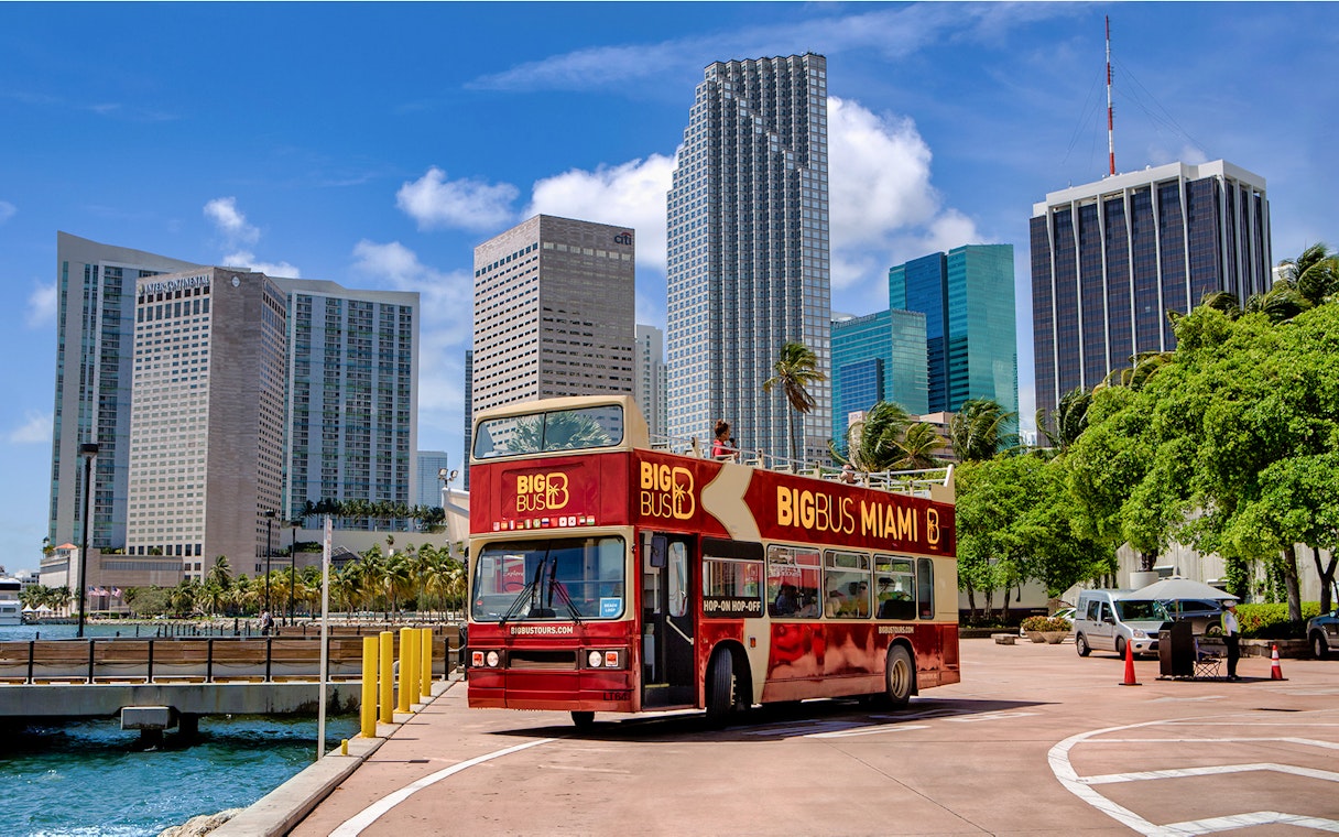 Big Bus Miami tour bus in front of downtown Miami skyscrapers.