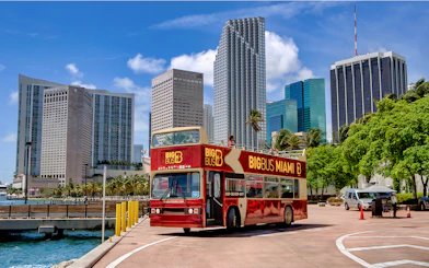 Big Bus Miami tour bus in front of downtown Miami skyscrapers.