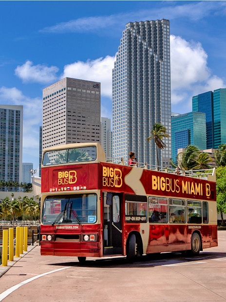 Big Bus Miami tour bus in front of downtown Miami skyscrapers.