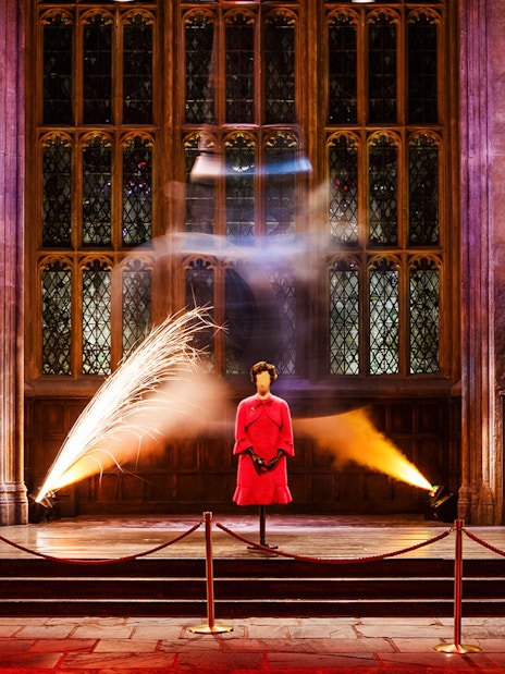 Exhibit at Magical Mischief Tour, Harry Potter London, featuring a pink outfit display in a grand hall.