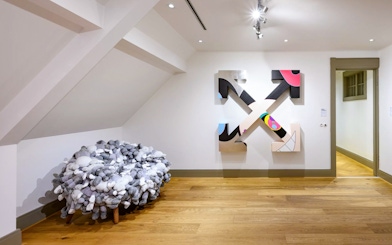 KAWS artwork and plush chair at Moco Museum, Amsterdam art tour.