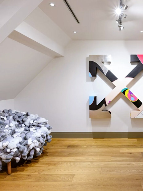 KAWS artwork and plush chair at Moco Museum, Amsterdam art tour.