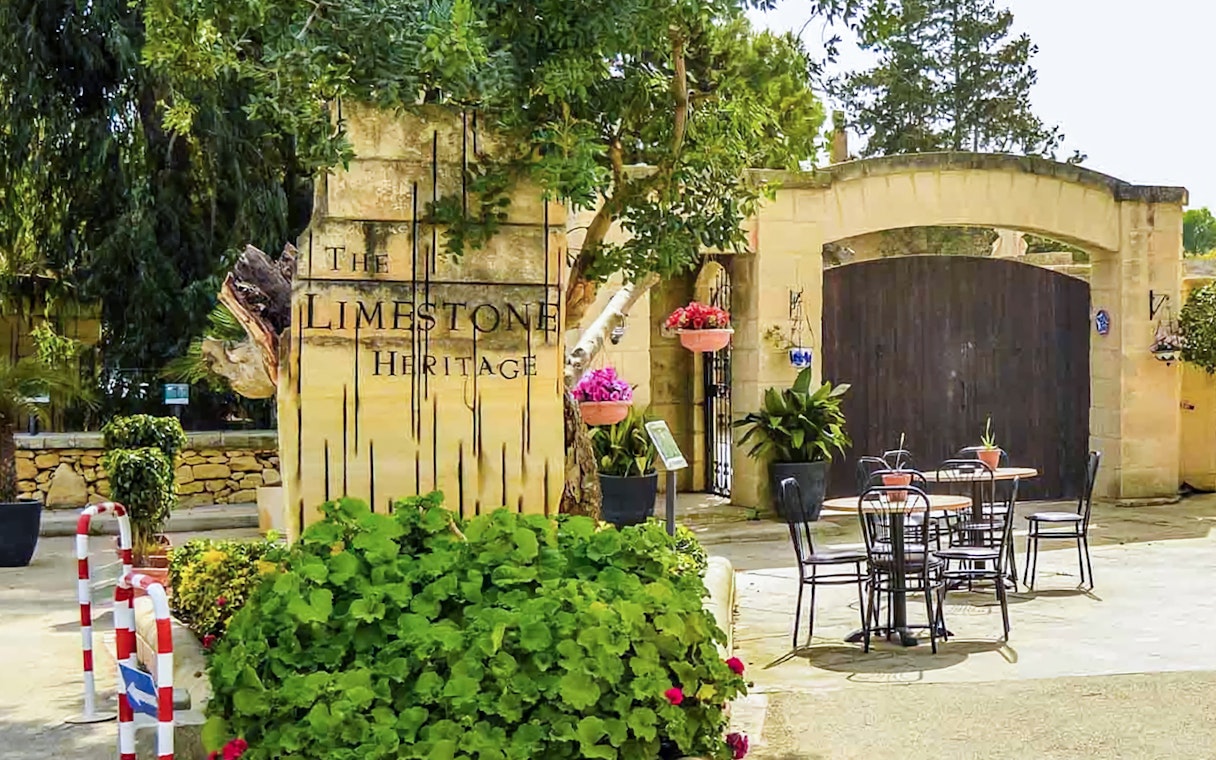 Limestone Heritage Park entrance with outdoor seating and lush greenery.