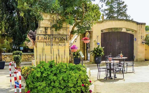 Limestone Heritage Park entrance with outdoor seating and lush greenery.