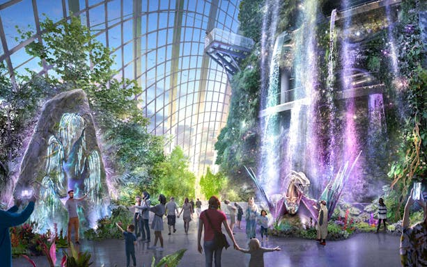 Gardens by the Bay indoor waterfall with visitors exploring lush greenery and colorful lights.
