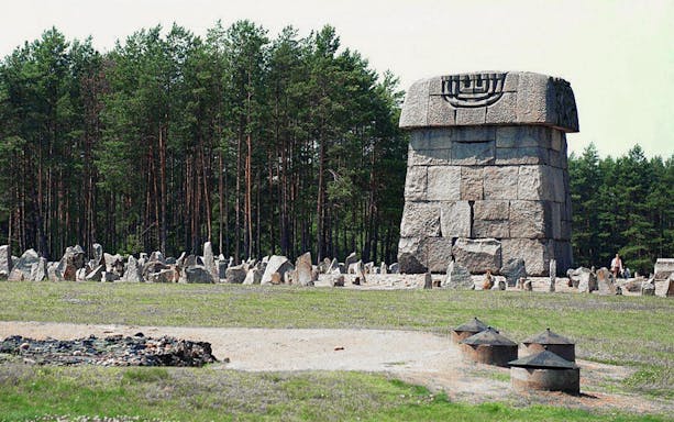 Treblinka Extermination Camp memorial stone with forest backdrop.