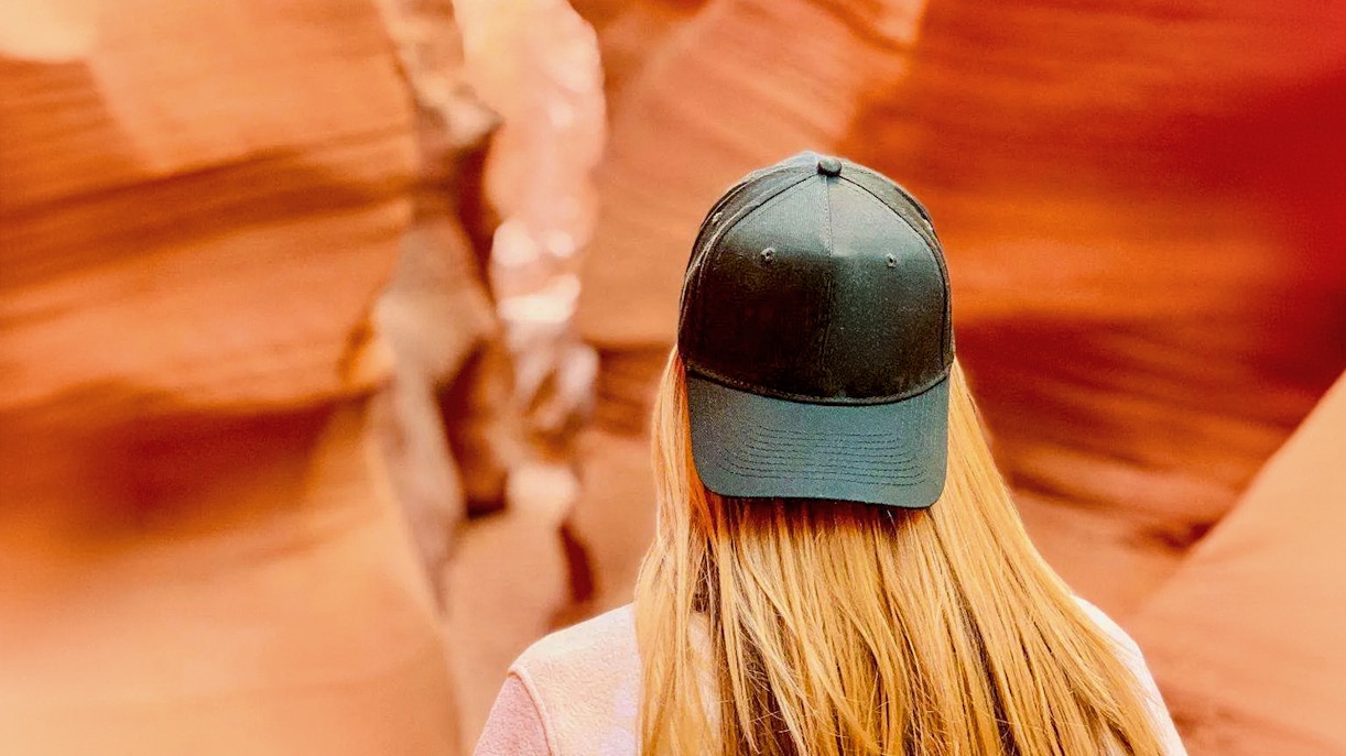 Visitor exploring the narrow sandstone walls of Lower Antelope Canyon.