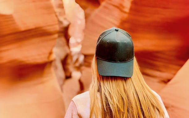 Visitor exploring the narrow sandstone walls of Lower Antelope Canyon.