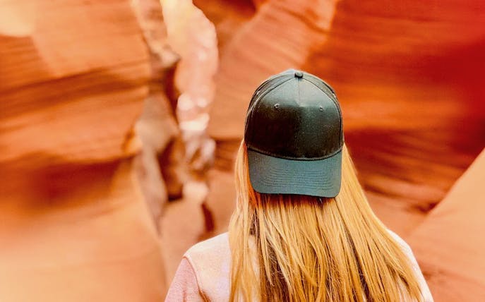 Visitor exploring the narrow sandstone walls of Lower Antelope Canyon.