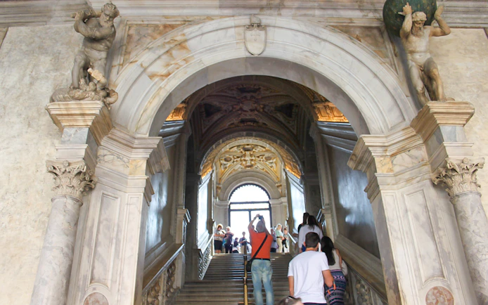 Visitors ascending staircase inside Doge's Palace, Venice.