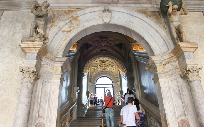 Visitors ascending staircase inside Doge's Palace, Venice.
