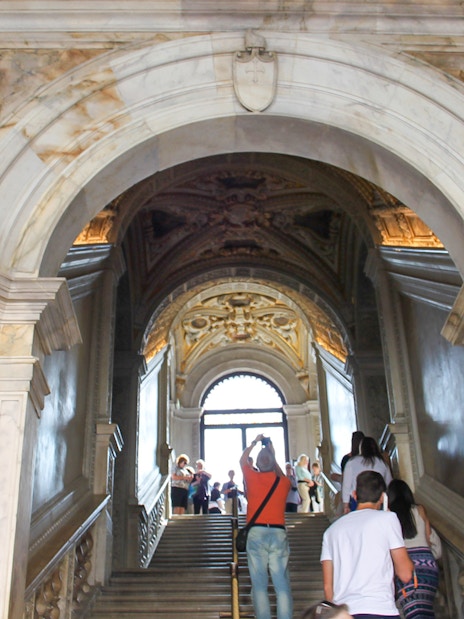 Visitors ascending staircase inside Doge's Palace, Venice.