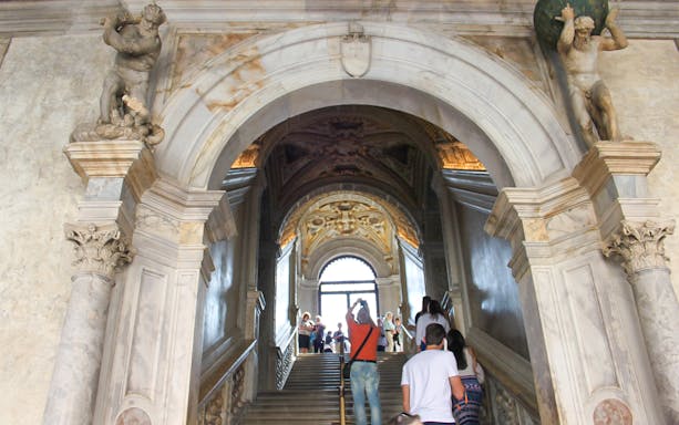 Visitors ascending staircase inside Doge's Palace, Venice.
