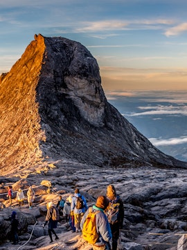 Hikers ascending Mount Kinabalu at sunrise in Malaysia.