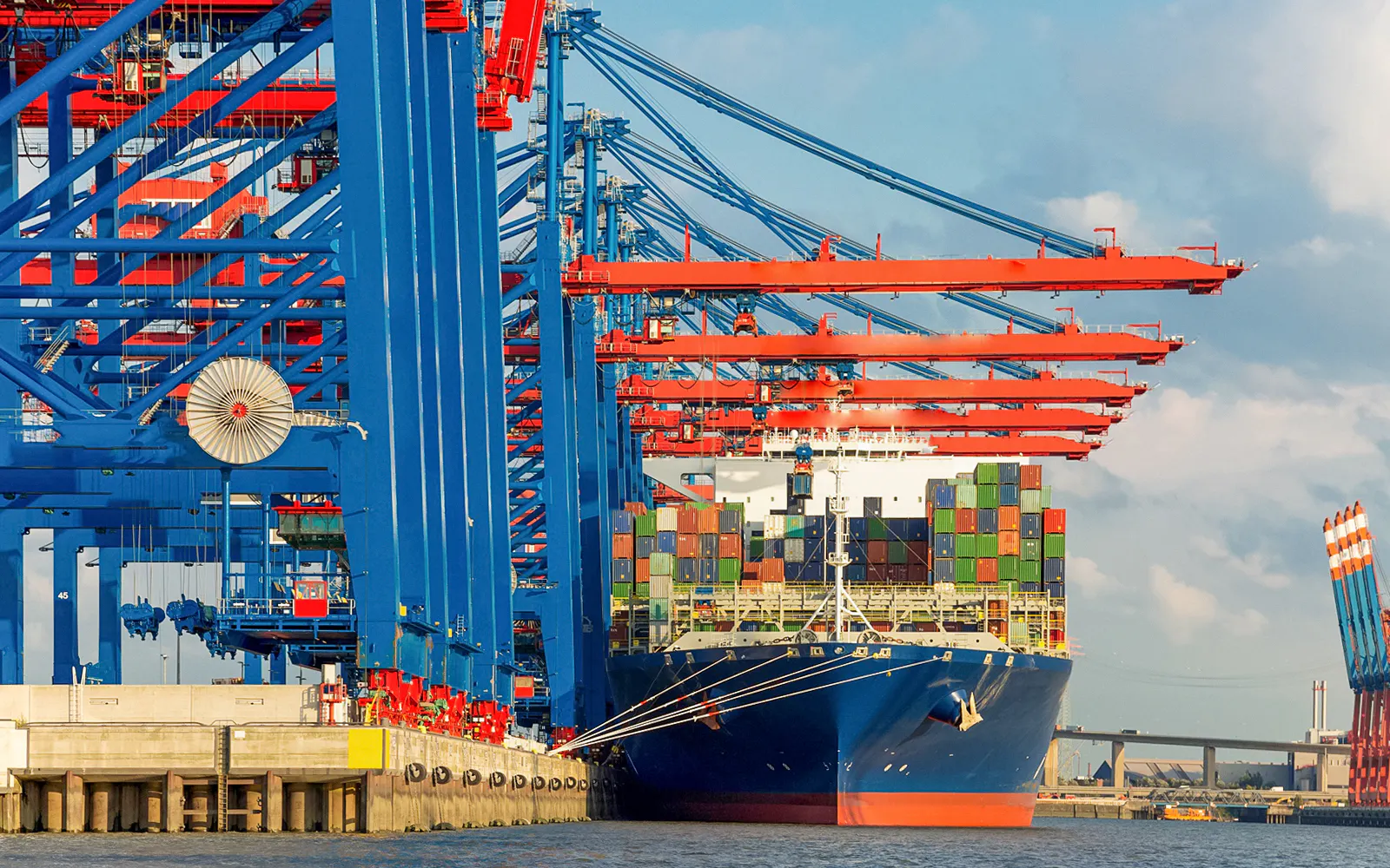 Container ship docked at Hamburg Harbor with cranes, seen on 2-hour boat tour.