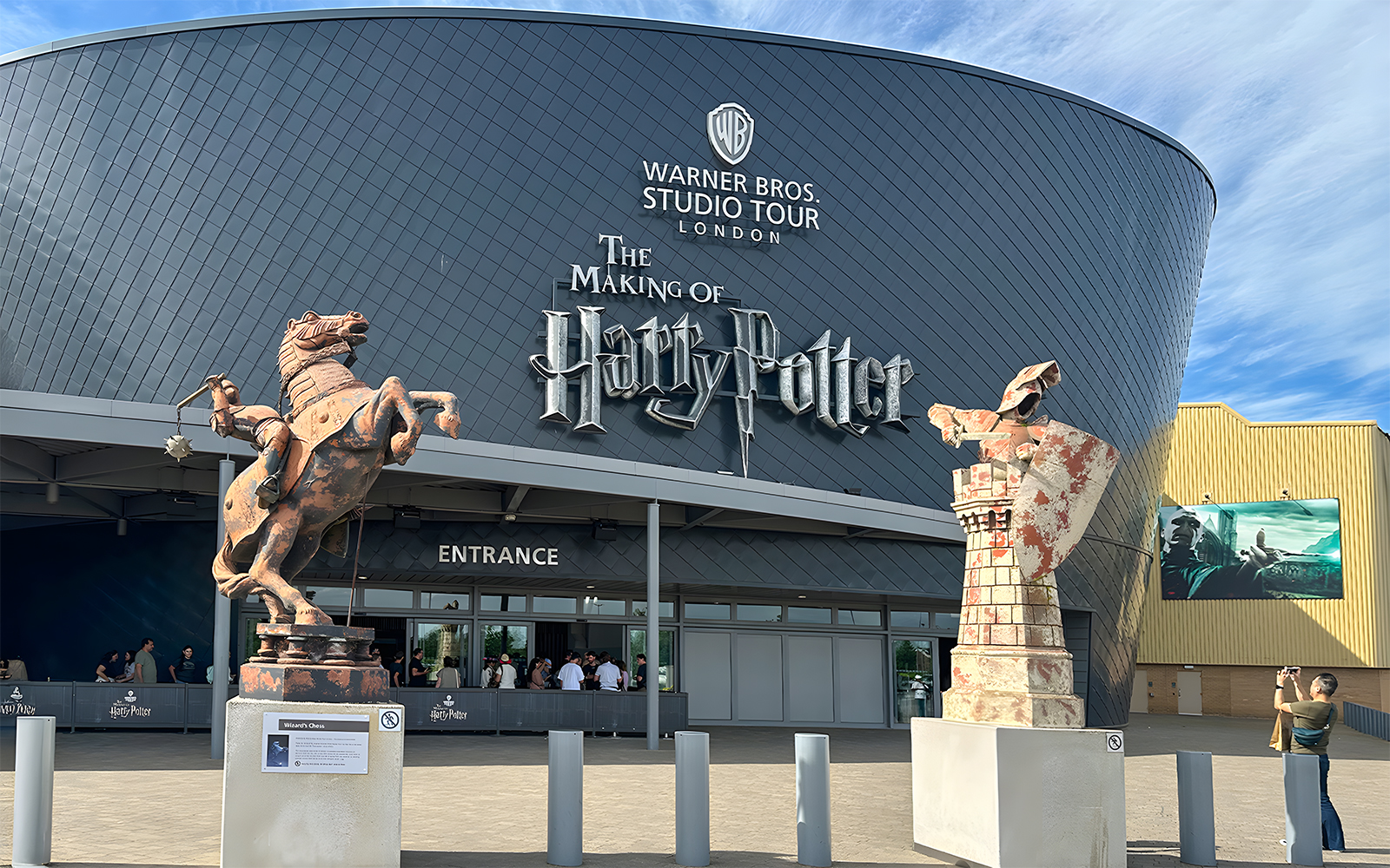 Warner Bros Studio Tour London entrance with Harry Potter statues.