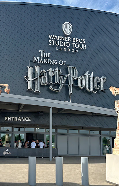 Warner Bros Studio Tour London entrance with Harry Potter statues.