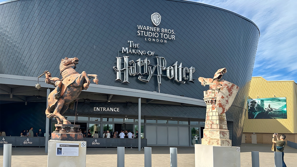 Warner Bros. Studio Tour London entrance with Harry Potter-themed decorations and visitors exploring.