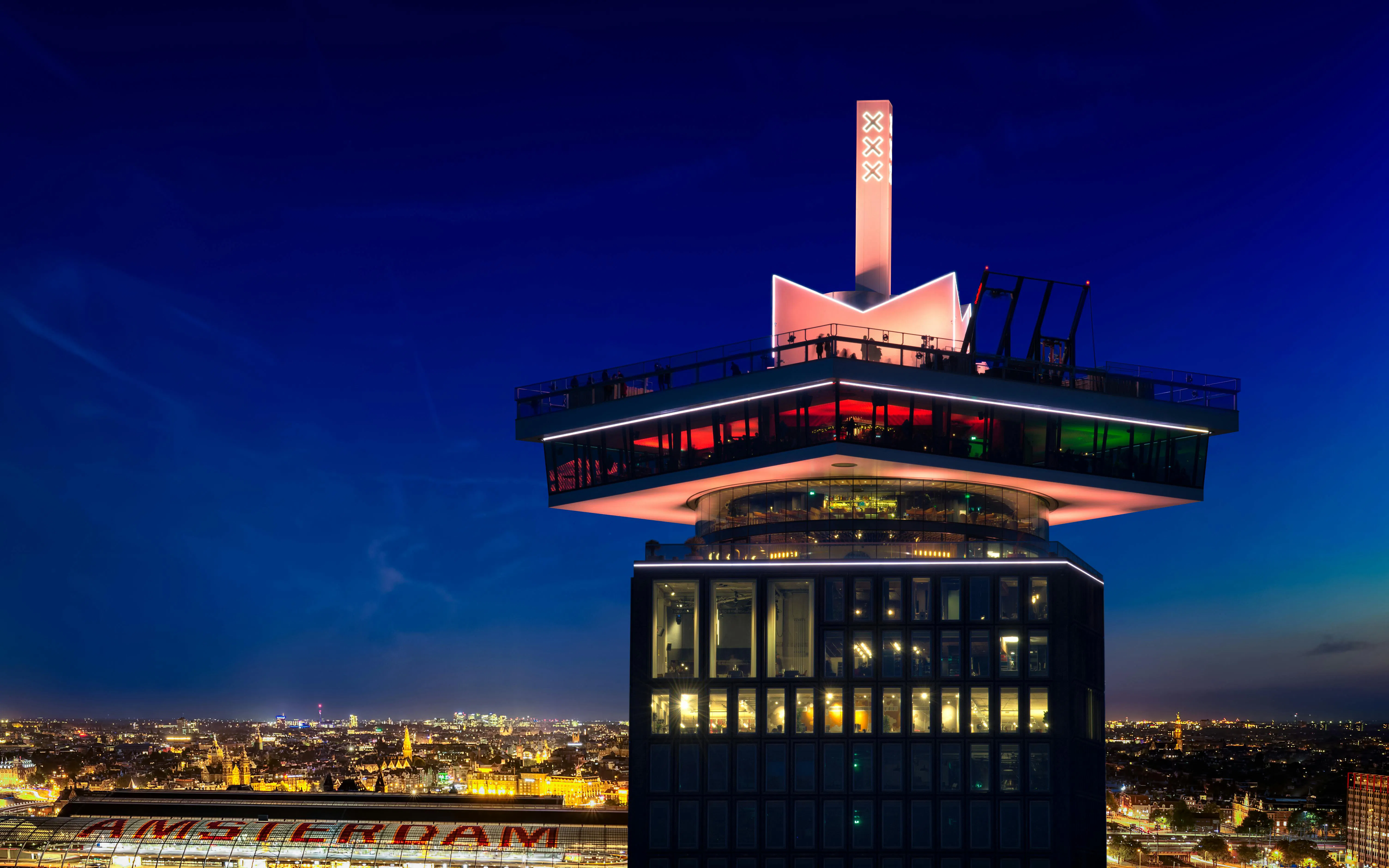 A'DAM Tower with illuminated skybar overlooking Amsterdam at night.