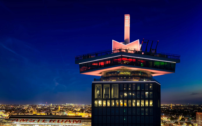A'DAM Tower with illuminated skybar overlooking Amsterdam at night.