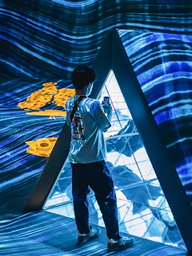 Person exploring digital art installation at Teamlab Forest Fukuoka.