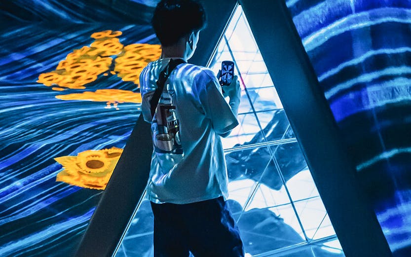 Person exploring digital art installation at Teamlab Forest Fukuoka.