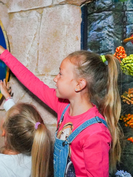 Young girls interacting with seahorse quiz at Sea Life Aquarium, Verona.