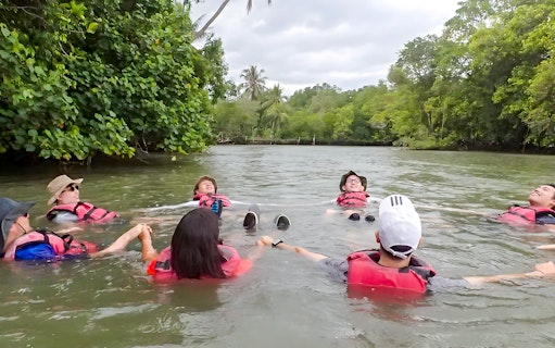 Kayakers relaxing in water at Pulau Ubin, Singapore, surrounded by lush greenery.