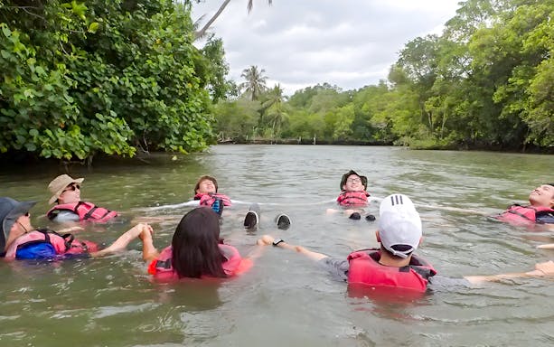 Kayakers relaxing in water at Pulau Ubin, Singapore, surrounded by lush greenery.