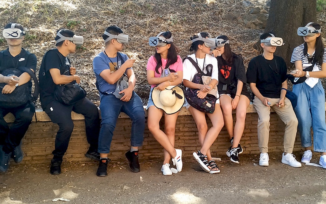 Visitors using VR headsets for a Colosseum tour in Rome.