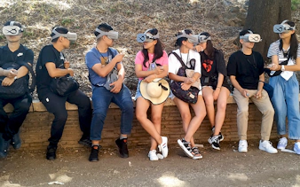 Visitors using VR headsets for a Colosseum tour in Rome.