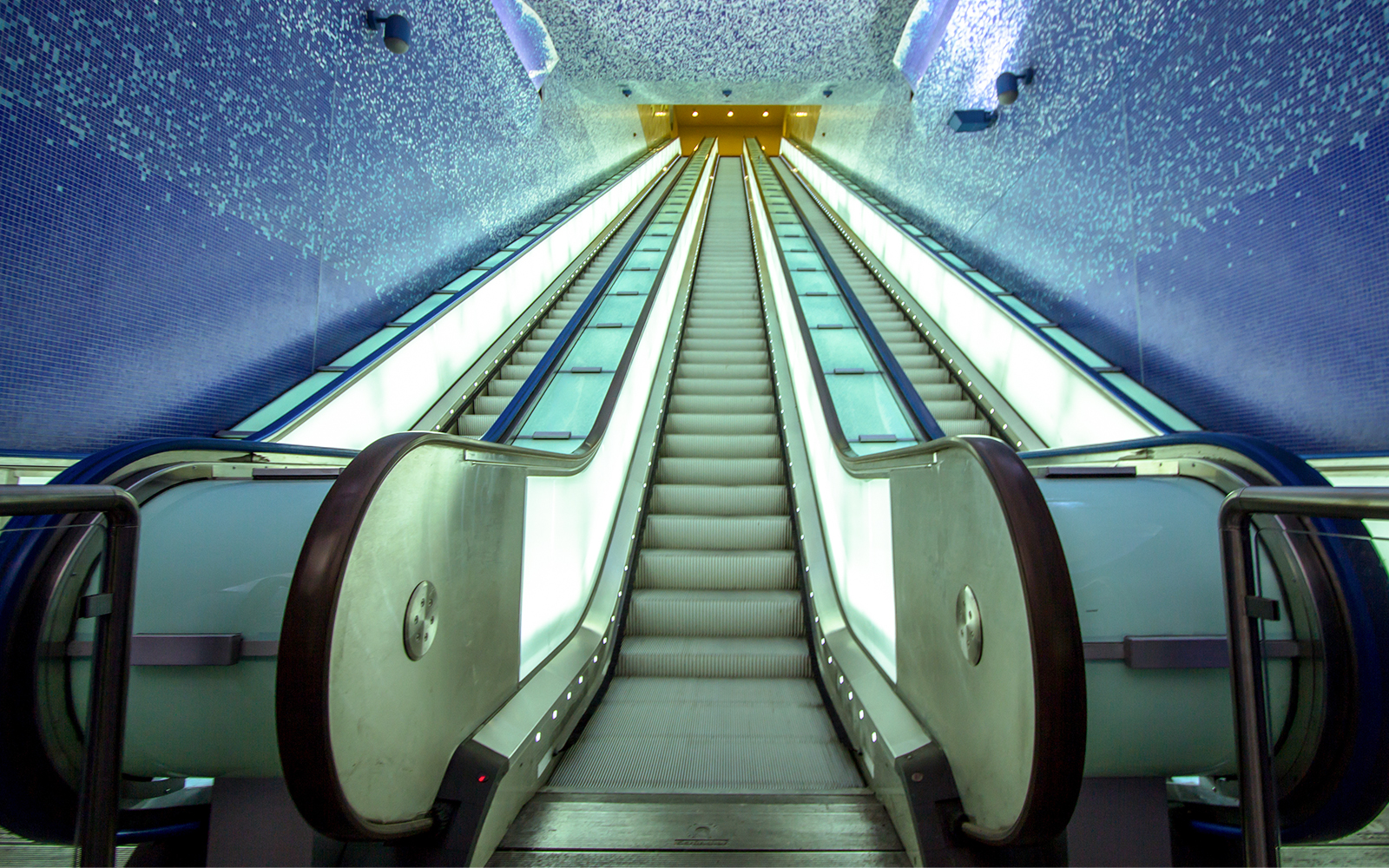 Toledo metro station escalator with vibrant lighting, Naples, Italy.