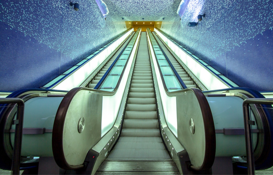 Toledo metro station escalator with vibrant lighting, Naples, Italy.