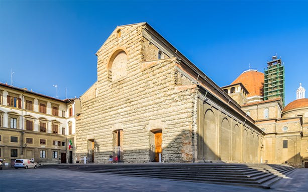 San Lorenzo Church exterior in Florence, Italy, showcasing its stone facade and architectural details.