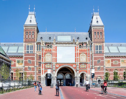 Rijksmuseum entrance with cyclists and pedestrians in Amsterdam.