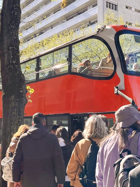 Tourists boarding a red double-decker bus for the Illumination Tour of Paris and Eiffel Tower.