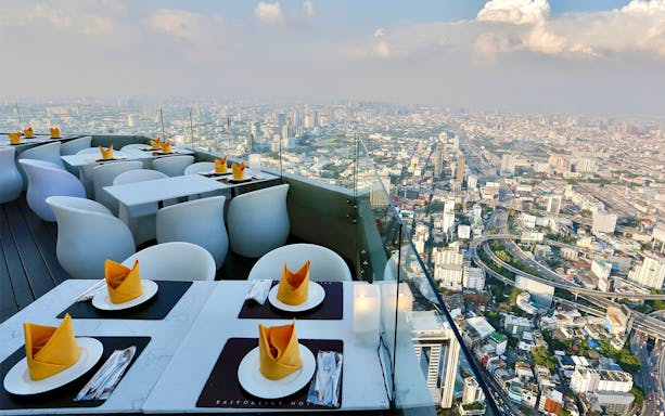 Rooftop dining setup at Baiyoke Sky Hotel with Bangkok city view.