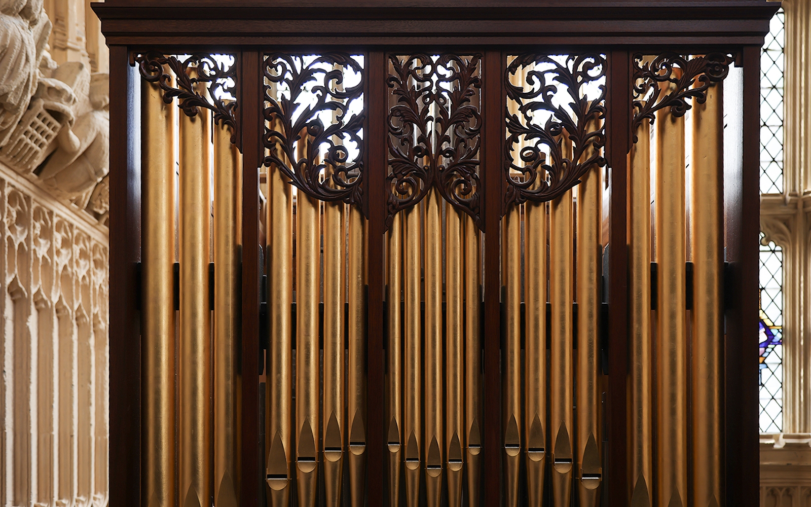 Pipe organ pipes with ornate woodwork in a church setting.