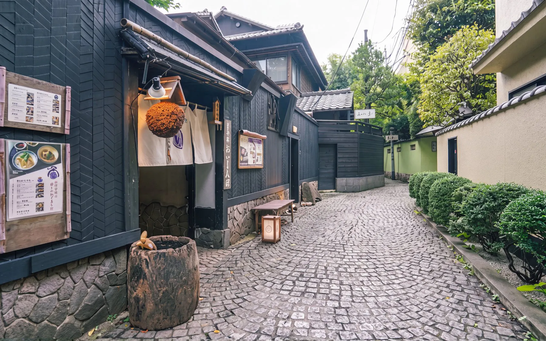 Traditional Japanese street in Tokyo with wooden buildings and cobblestone path.