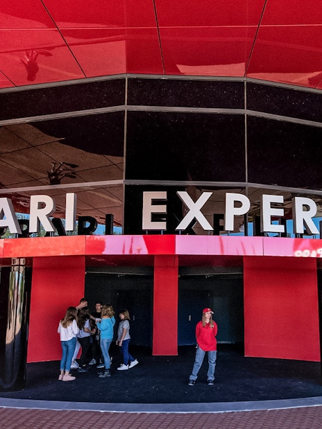 Ferrari Land entrance with visitors at the Ferrari Experience building.