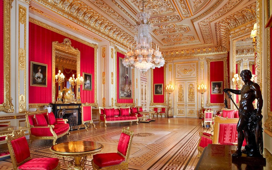 Crimson Drawing Room in Windsor Castle with ornate gold decor and chandeliers.