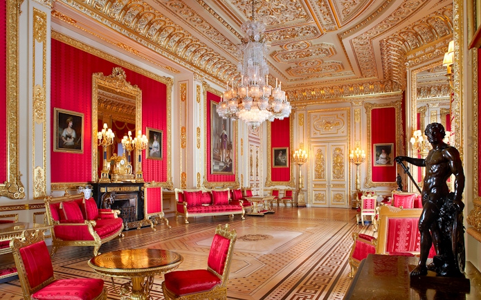 Crimson Drawing Room in Windsor Castle with ornate gold decor and chandeliers.