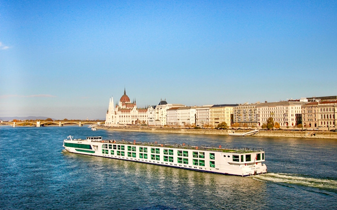 Cruise ship on the Danube River with Budapest Parliament in the background.