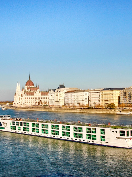 Cruise ship on the Danube River with Budapest Parliament in the background.