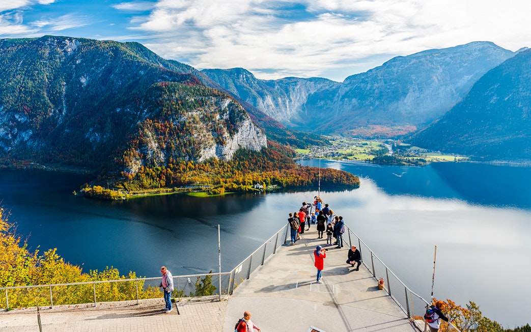 Visitors on the Skywalk lookout bridge overlooking Hallstatt, Austria's lake and mountains.